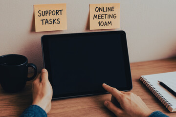 Poster - An individual is preparing for an online meeting highlighting business tasks with notes while using a tablet to strategize effectively