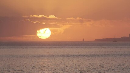 Wall Mural - golden sun setting over a calm ocean, painting the sky with warm hues, a distant sailboat adding a t