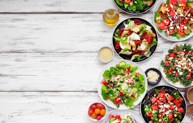 Poster - Variety of delicious fresh salads. Overhead view side border on a white wood background. Summer food concept.