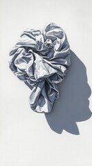Poster - Silver fabric artfully draped casting a soft shadow on a textured white surface creating a sense of luxury and minimalist elegance with a modern aesthetic