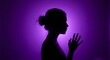 © Tgad - Silhouette of a woman with her hand extended, bathed in a soft purple light from behind. Violence against women. Femicide.