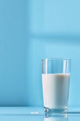 Poster - refreshing glass of fresh milk against a serene blue backdrop casting soft shadows creating a minima