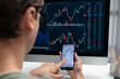 © InfiniteFlow - Smart stock investors pointing on screen with smartphone for market stock exchange along with laptop screen in highest dynamic investment rate, focusing data planning at modern workplace. Pecuniary.