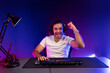 © InfiniteFlow - Winner of smart streamer playing online game wearing headphones raising fist up on streaming gamer with social media. Esport skill team player online digital gaming at neon light studio room. Surmise.