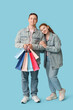 © Pixel-Shot - Beautiful young couple with shopping bags on blue background