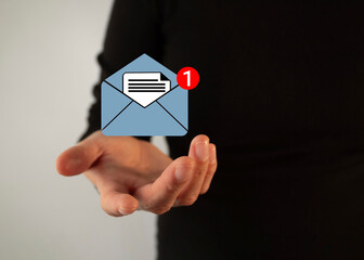 Poster - Businesswoman's hand holding an icon of an open email envelope with a notification