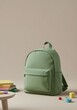 © raditya18 - Mockup of a small green canvas children's backpack placed upright in an indoor studio