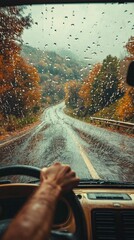 Aufkleber - A person grips the steering wheel while navigating a winding road amidst a vibrant autumn landscape. Rainfall creates a misty atmosphere, enhancing the colorful leaves surrounding the highway