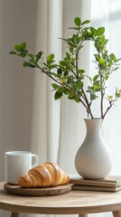 Fototapete - A cup of coffee sits next to a golden croissant on a wooden plate. A vase holds green branches, creating a serene, cozy atmosphere in a bright space