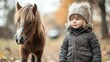 © Soknea - A fluffy miniature horse standing next to a child