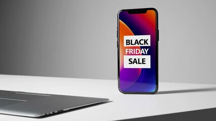 Poster - Resting near laptop on white studio table, modern smartphone displaying vibrant black friday sale advertisement against minimalist grey background