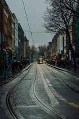 Naklejka na meble Dublin, Ireland - February 15 2025: Dublin City Centre - A yellow tram in between buildings on an overcast afternoon