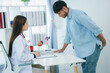 © PSG - A man is consulting a doctor about hemorrhoids. Squeezing his buttocks. Sees a proctologist to discuss anal problems. Hemorrhoids or treatment concept