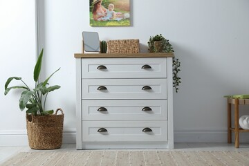 Poster - Dresser with stylish decor and houseplants near white wall indoors