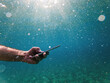 © Bits and Splits - Male diver using smartphone device underwater in deep blue sea during summer holiday vacation