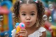© TrungKien - A little girl in the park, playing with a water gun and soap bubbles on a sunny day.