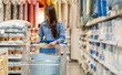 © Art_Photo - Asian woman shopping in home goods store smiling while pushing cart through bedding section, enjoying retail lifestyle, consumer behavior, weekend leisure, home decor at modern market