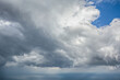 Dark storm clouds gathering in moody sky, dramatic weather background with grey overcast atmosphere.

