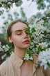 © Westend61 - Young woman with closed eyes standing by a blossoming apple tree outdoors