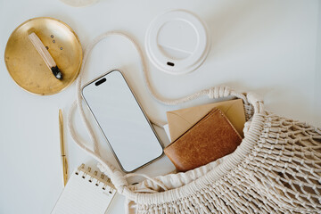 Wall Mural - Flat Lay of Smartphone and Notebook with Cotton Bag, Golden and Neutral Tones