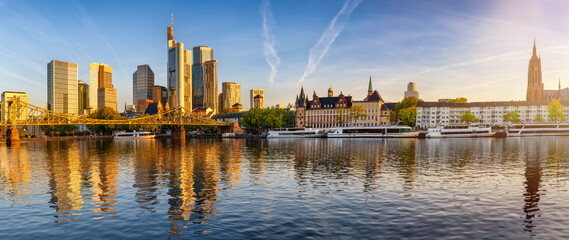 Fototapete - Panoramic view of the skyline of Frankfurt am Main, Germany, with Eiserner Steg bridge, office skyscrapers and Kaiserdom church during a golden sunrise