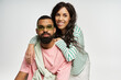 © LIGHTFIELD STUDIOS - Stylish couple embraces love in trendy outfits with joyful expressions in a vibrant studio setting