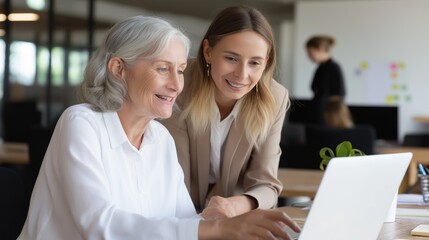 Poster - Two enthusiastic female employees engage in a collaborative effort at their workspace. They appear joyful while sharing ideas and working on a laptop, creating a positive atmosphere
