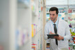 © ultramansk - man pharmacist checks and arranges medicines on pharmacy shelves, emphasizing precision and responsibility in healthcare services. The scene highlights the daily operations in a modern pharmacy.