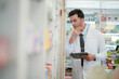 © ultramansk - man pharmacist checks and arranges medicines on pharmacy shelves, emphasizing precision and responsibility in healthcare services. The scene highlights the daily operations in a modern pharmacy.