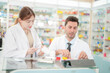 © ultramansk - team man and woman pharmacist inspects a medication bottle, ensuring accuracy in prescription filling. pharmacists in patient safety and careful medication handling. operations in retail pharmacy.