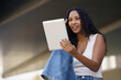 © javiindy - A young woman happily engaged with her tablet while enjoying the outdoors in nature