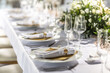 © weyo - A wedding table covered with a white tablecloth, decorated with flowers, candles, glasses and cutlery