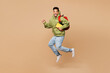 © ViDi Studio - Full body young fun boy student he wear green casual clothes backpack bag hold books do winner gesture jump high isolated on plain pastel light beige background High school university college concept