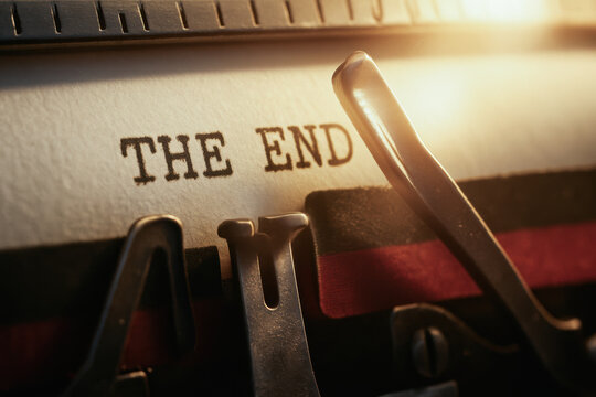 Concept of termination is captured with close up of typewriter printing words THE END in warm light