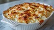 © Blackmint Studio - A small baking dish holds creamy macaroni and cheese, beautifully browned on top. This comforting dish invites indulgence and is perfect for a cozy meal at home or a friendly gathering