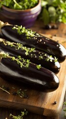 Poster - Three fresh eggplants on wooden cutting board with sprigs of thyme garnish close up studio shot healthy food preparation