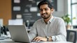 © Adobe Contributor - Smiling Person Working on a Laptop in Office
