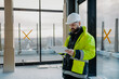 © Halfpoint - Construction site manager using digital tablet to inspect building progress.
