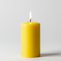 Poster - A single yellow pillar candle burning with a bright flame on a plain white background in studio lighting
