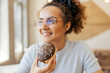 © Dusan Petkovic - Selective focus on hungry girl's hand holding doughnut in fast food restaurant.