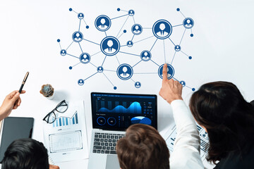 Fototapete - Professional teamwork discussing networking strategies and data analysis with graphs and charts on laptop in modern office setting. Amity