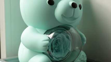 Poster - Close-up view of a small toy bear sitting on a window sill, perfect for decorating a nursery or playroom
