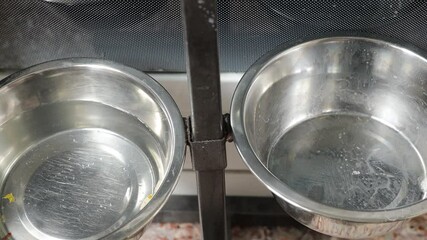 Poster - Two metal bowls sit atop a stove, ready for cooking or serving