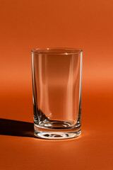 Aufkleber - Sleek glass illuminated against a vibrant orange backdrop. Minimalism in form and striking color contrast create an elegant visual statement.