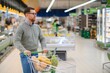 © Serhii - A man with a cart walks in a supermarket