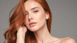 © KeetaKawee - Beautiful young woman with flowing red hair posing against a neutral background