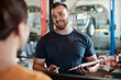 © peopleimages.com - Mechanic, man and customer talk with car report and clipboard for maintenance and repair check. Conversation, garage and motor inspection with paperwork and auto consultation for technician job