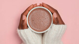  Close-up of a Black woman's hands wearing a white sweater, holding a hot pink mug of cocoa against a solid pastel background, in a flat lay composition.