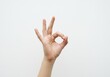 © stock.metket.com - Hand gesture of 'ok' or perfection against a white background, conveying approval and satisfaction