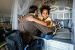© NDABCREATIVITY - Multiethnic, diverse daughters and single father in a wheelchair sharing a warm moment at home